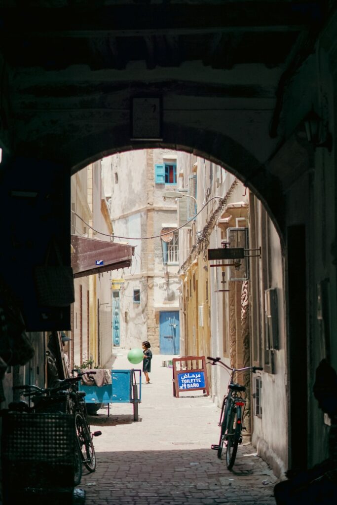 a person walking down a narrow alley way