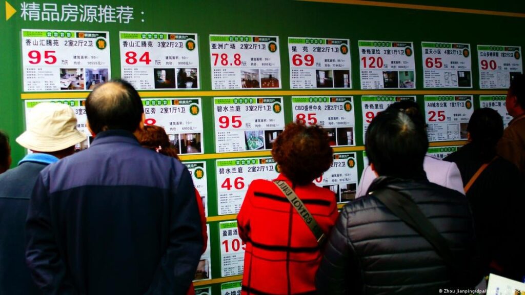 Homebuyers view ads of pre-owned apartments at a real estate fair in Yichang city, Hubei province, China, on November 18, 2016