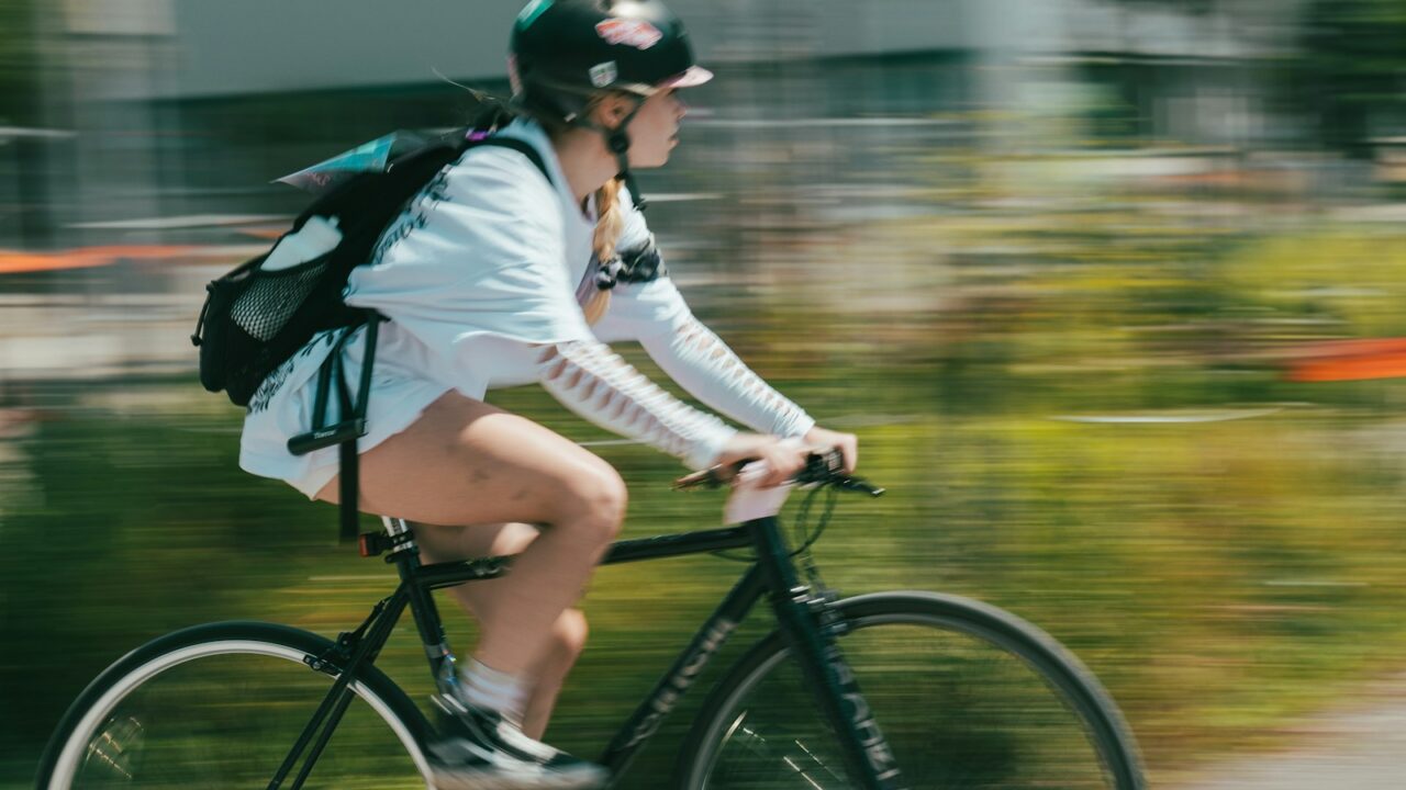 A woman riding a bike down a street