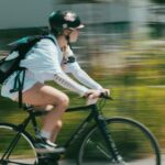 A woman riding a bike down a street